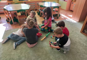 Grupa dzieci buduje z klockó